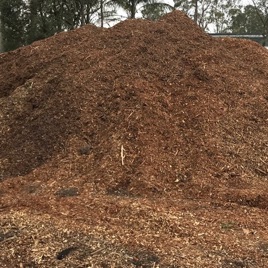 Aged forest mulch pile, dark brown seasoned wood chip ready for delivery, Brisbane