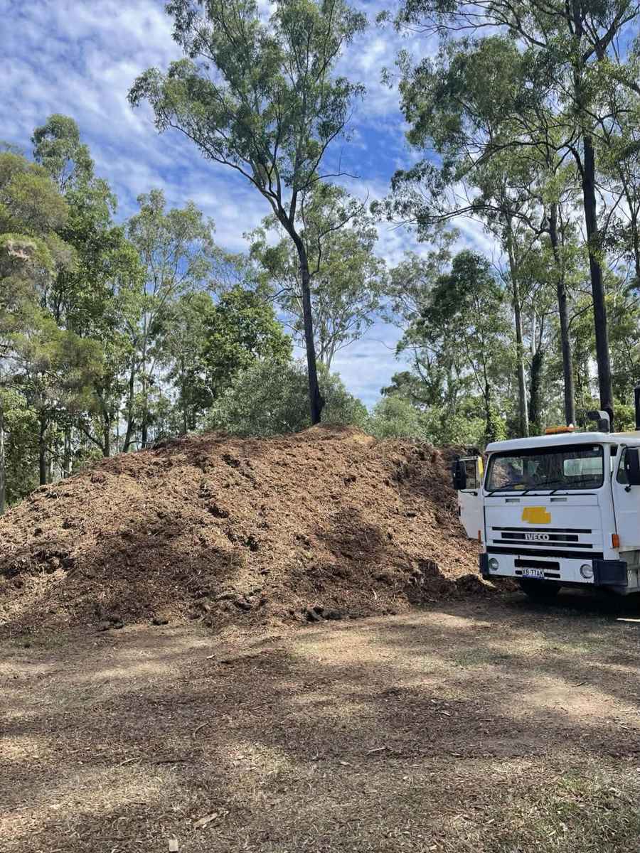 Tipper truck beside a 20 cubic metre aged forest mulch pile on an acreage block, Brisbane south-west